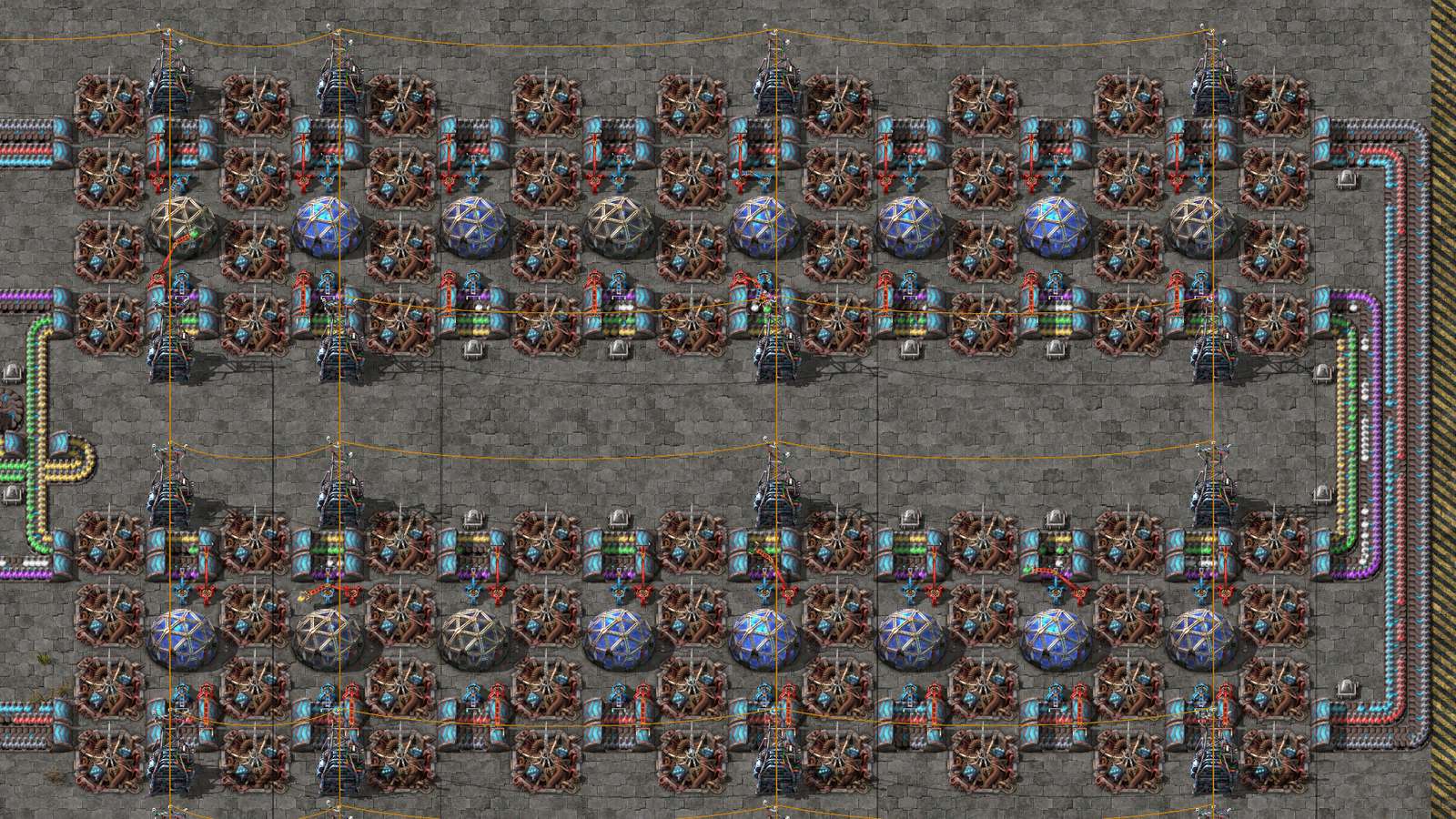 A Factorio base at night lit by lamps
