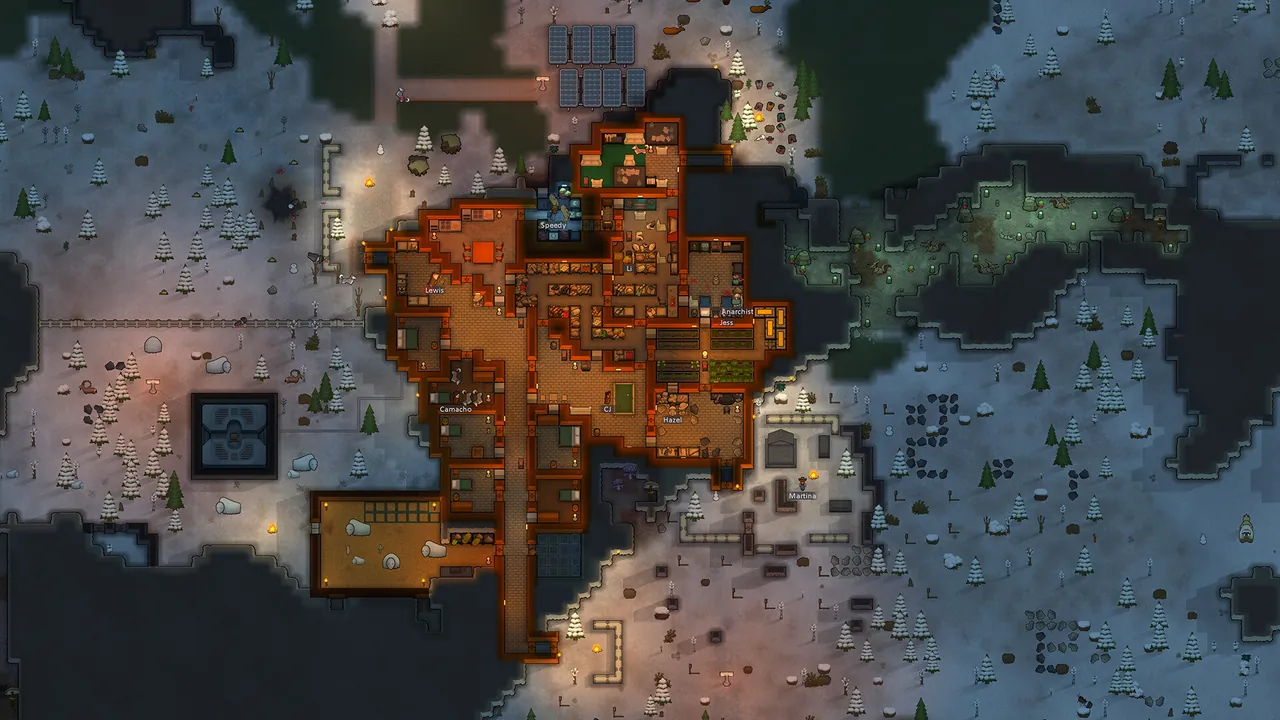 A RimWorld colony base sprawled across a snowy map, seen from above